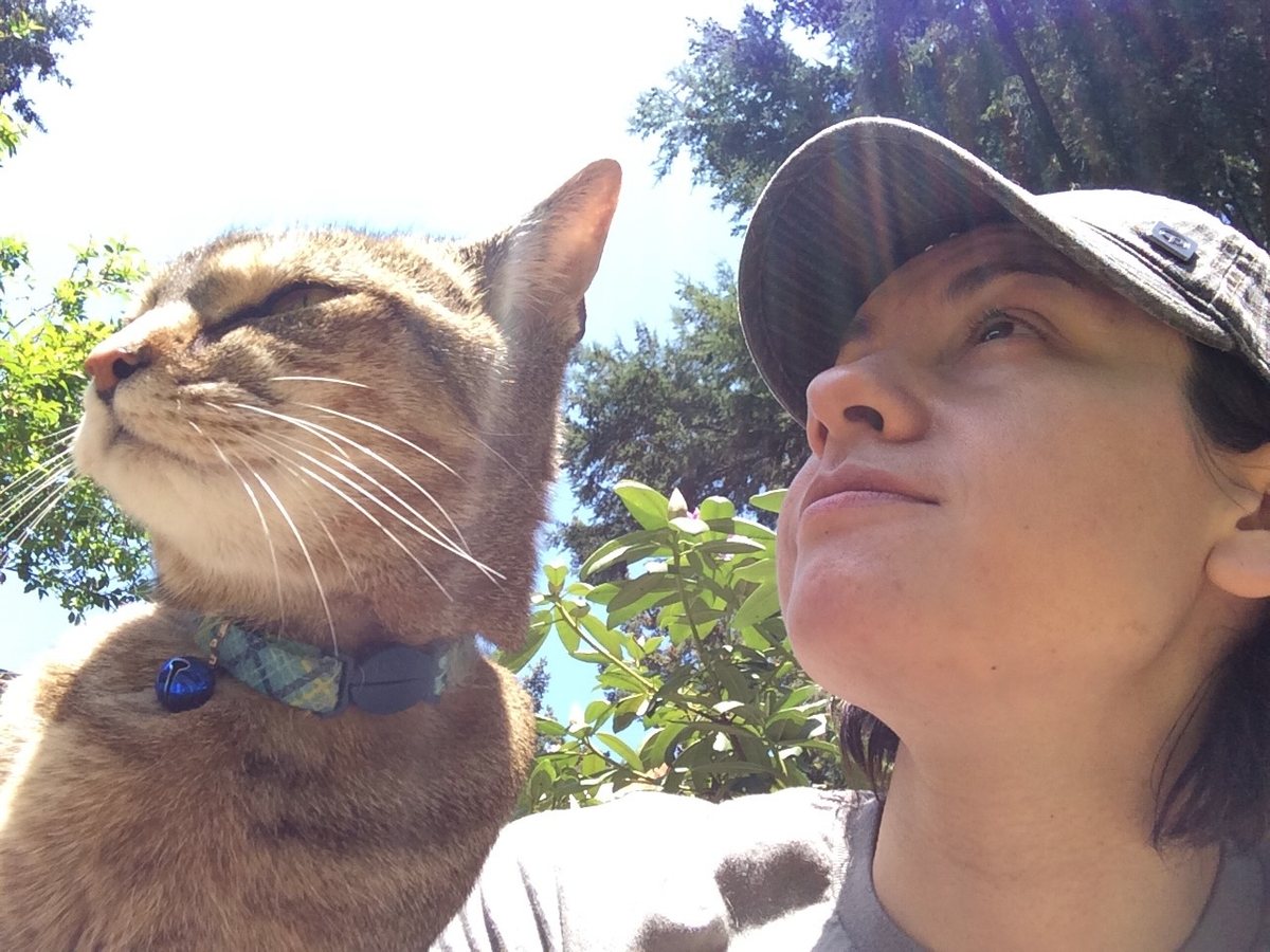 Riley taking a selfie with a cat, both looking up